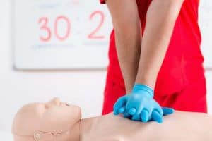 Personne effectuant un massage cardiaque sur un mannequin chez SantePrev